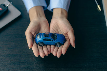 Car rental sales concept, Asian businesswoman working with toy cars on the table. Concepts of cars, property, ownership, insurance and transportation.の写真素材