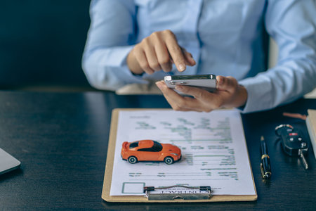 Car rental sales concept, Asian businesswoman working with toy cars on the table. Concepts of cars, property, ownership, insurance and transportation.の写真素材