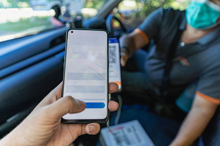 Delivery concept of young man paying via mobile banking app from delivery manの写真素材