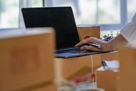 Online business idea, young sme entrepreneur, working from home with laptop and smartphone to take...