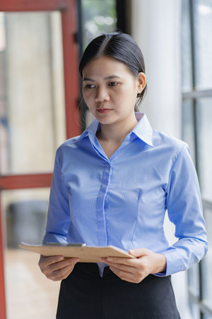 Asian woman standing with laptop in office online working conceptの写真素材