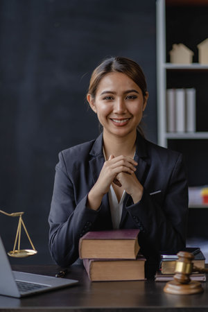 female lawyer on the background goddess of justice with scales and hammer judge lawyer working on laptop, law, advice and justice conceptの写真素材