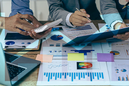 business people meeting to analyze and discuss and brainstorm data charts financial reports...