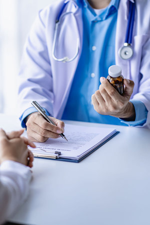 Doctors and patients sit and talk to patients about medications. At the table near the window in the hospital Female doctor talking, examining the little patient and the doctor taの写真素材
