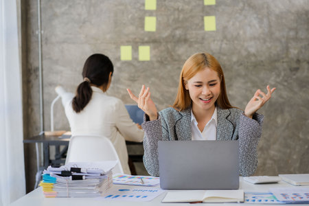 Finance concept and collaboration Two young female accountants in casual clothes work on laptops and...