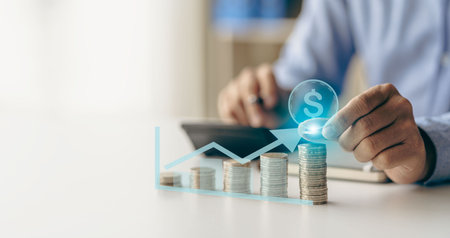 Money savings concept, pile of coins with blurred man background Family savings and growing business with stacks of coins lined up like a graph.の写真素材