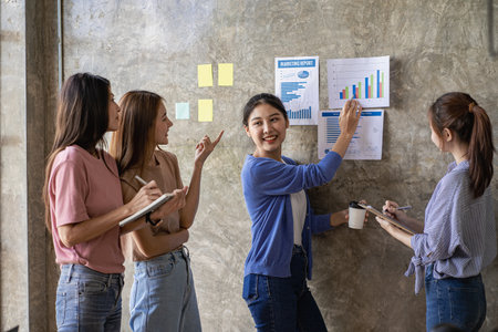 Group of young businessmen brainstorming at a meeting to start a new business In modern office with financial graph and laptopの写真素材