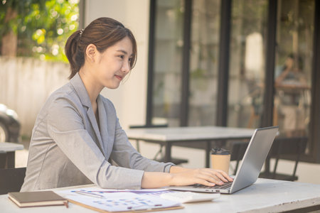 Young Asian female accountant working on laptop computer and finance at work, freelance business, online marketing, e-commerce marketing concept.の写真素材