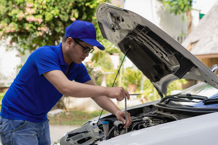 Home service mechanic checking car engine. Car service. Asian man opens his convertible and inspects his car. transportation conceptの写真素材