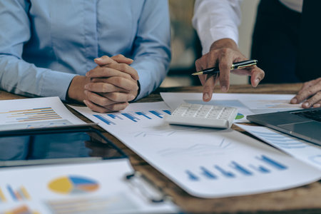 Businessman working on stock market investment chart with financial data analysis Two business colleagues discussing financial and company planning graphs during budget meeting inの写真素材