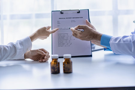 Psychiatrist consulting on women's gynecological diseases, writing prescription clipboard notes, listening to patients received in the clinic hospital.の写真素材