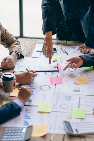 Group of business people holding pen brainstorm financial analysis with financial graph document Calculator and computer to calculate budget and loan. Investment. Vertical image.の写真素材