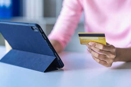 Businesswoman holding credit card online shopping with tablet Attractive woman holding credit card and doing financial transaction online and online shopping with smartphoneの写真素材