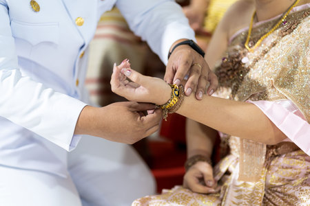 Sacred thread tied in a Thai wedding ceremony The hands of the bride and groom are tied with threads. Thai wedding culture with Orapornの写真素材