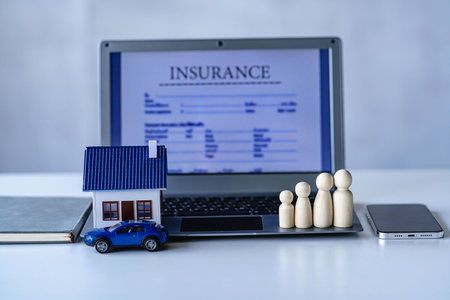 Insurance covers a mock-up of a house placed on a laptop. Real estate, insurance and property to protect home and family from harm, insurance conceptの写真素材