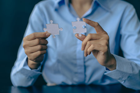 hand holding a piece of white jigsaw puzzle, joint path to solution, finding a way out of a...