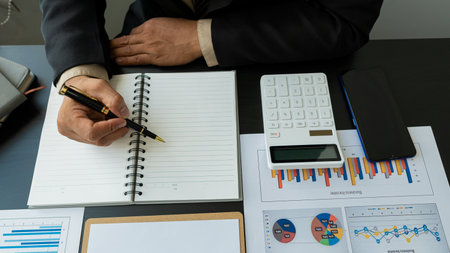 Hands of financial manager analyzing reports on desk, business plan and analyzing many chart graphs...