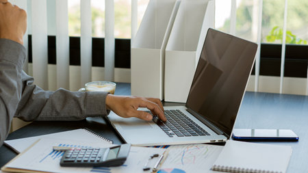 Businessman hands on keyboard of laptop computer showing data analysis graph Businessman working and...