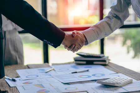 Successful negotiation and handshake concept Two businessmen shake hands with partners to celebrate cooperation and teamwork, mergers and acquisitions. Successful negotiations, busの写真素材