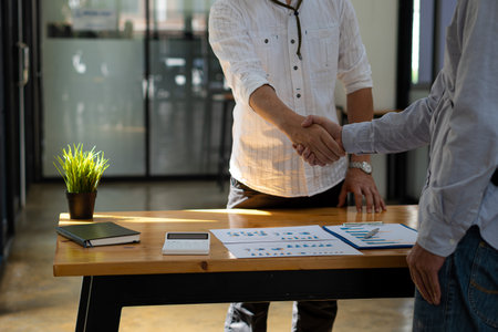 Successful negotiation and handshake concept Two businessmen shake hands with partners to celebrate cooperation and teamwork, mergers and acquisitions. Successful negotiations, busの写真素材