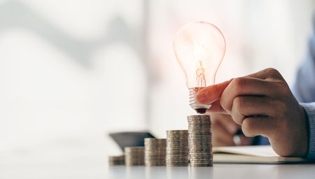 Energy saving and money concept in saving or investment Businessman holding light bulb beside piggy...