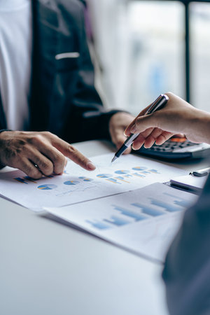 Businessmen meeting using laptop computers calculator stock market chart paper for analysis Quality improvement plan in business idea discussion meeting vertical imageの写真素材