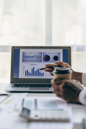 Businessmen meeting using laptop computers calculator stock market chart paper for analysis Quality improvement plan in business idea discussion meeting vertical imageの写真素材