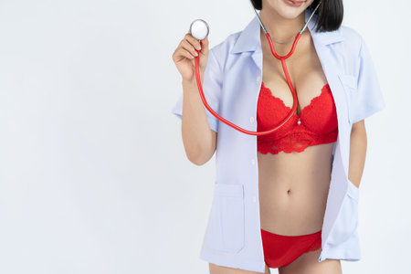 hot sexy girl Play the role of a naughty nurse. listen to the stethoscope Red bikini in shade against white backgroundの写真素材