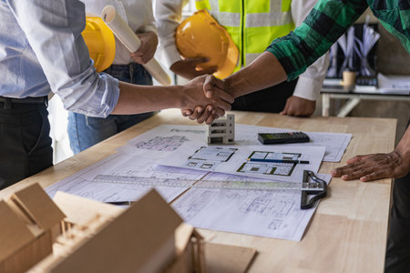 Engineers work as a team with blueprints for architectural plans. Engineer sketching construction project concept with architect equipment Architect and foreman talking at tableの写真素材