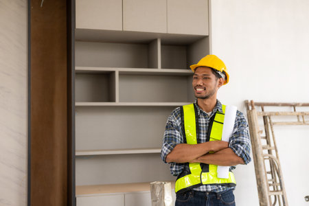 Portrait of young male engineer contractor in work clothes standing at construction siteの写真素材