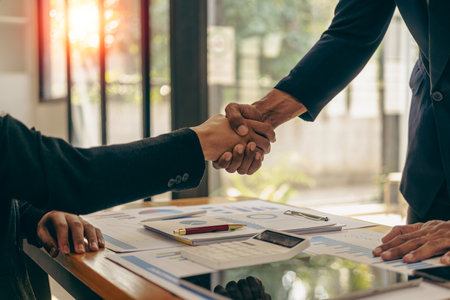 Two confident businessmen shaking hands during meeting in office Successful collaboration and contact Greetings and Partnerships in the Real Estate Businessの写真素材