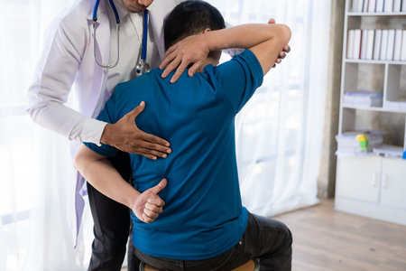 Young Asian man doing physiotherapy and seeking advice from muscle pain with shoulder, limbs in rehabilitation center.の写真素材