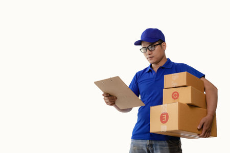 Young Asian delivery man holding a cardboard box Image of delivery boy in blue cap standing with mailbox isolated on white backgroundの写真素材