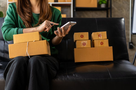 Small Business Startup SME Owner Asian Woman Checking Online Orders Sell ââgoods, work with boxes. home office freelance work online sme business delivery conceptの写真素材