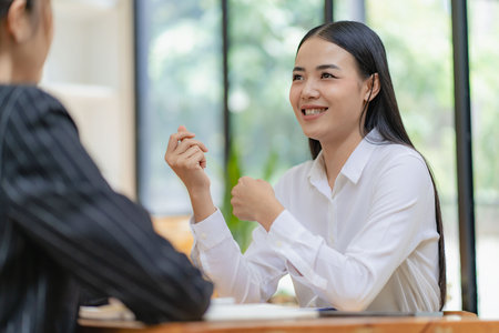 business woman making a presentation in front of colleagues Businesswoman consultant explaining financial charts in corporate group training with laptop and financial papers on tabの写真素材