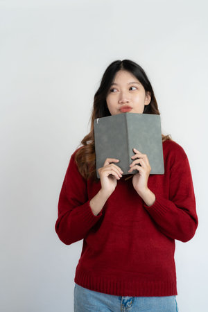 Asian girl student holding book white background, study conceptの写真素材
