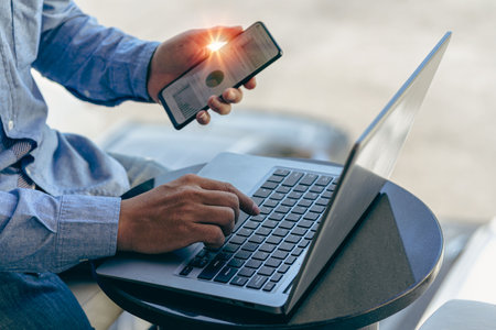 Confident businessman working on laptop, tablet and smartphone in her workplace at office corporate communication male manager working remotely Read financial documents and talk onの写真素材