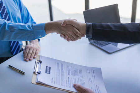 Close-up shot of businessman shaking hands with job seeker Managers who are willing to successfully agree with new candidates Professional employees greet applicants at their desksの写真素材