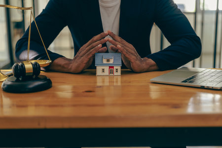 Consultation, contract agreement, lawyer focused on court hammer sitting on chair with client's indictment to settle home and land in court house auction conceptの写真素材