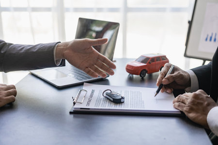 Young man signing car insurance or rental documents Transportation finance cost management planning Concept of auto insurance businessの写真素材