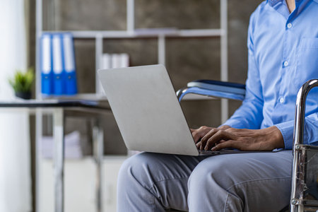 Hands of young contemporary office manager on laptop keypad during work. Young businessman working on laptop in modern bright coworking office copy spaceの写真素材