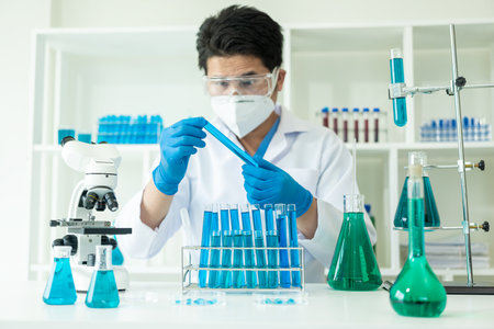 Researcher with chemical test tubes in a glass laboratory with liquid for analytical, medical,...