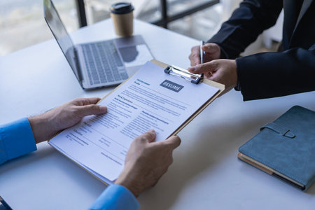Executive reading resume during job interview and businessman filling in application form Concept of successful hiring and recruitment of human resources.の写真素材