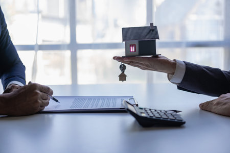 Real estate brokers present and give advice to customers who buy houses, along with recommending insurance as a free gift.の写真素材