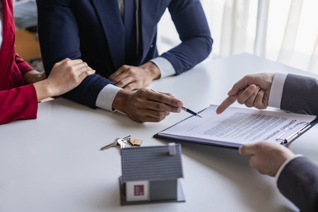 Real estate brokers present and give advice to customers who buy houses, along with recommending insurance as a free gift.の写真素材