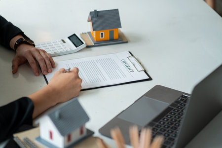 Real estate brokers present and give advice to customers who buy houses, along with recommending insurance as a free gift.の写真素材