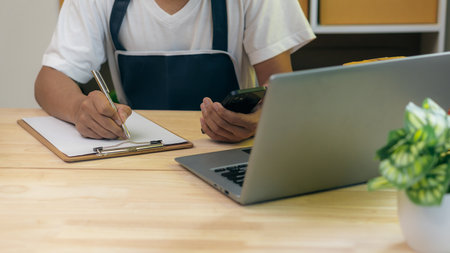Entrepreneurs Small Business SME Independent men work at home Use smartphones and laptops for...