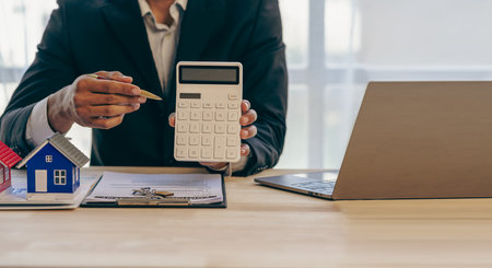 The concept of buying and selling real estate housing estates. The salesperson calculates the price and explains the details of the transaction to the customer and gives advice onの写真素材