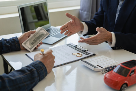 Car business, car sales, transportation, people and ownership. Close-up shot, customer signs a contract and pays, sales manager offers to sell the car and explains the condition ofの写真素材