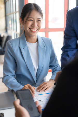 Young asian business people financial analysis meeting brainstorming on new business together with laptop and financial accounting graph papers in officeの写真素材